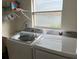 Bright laundry room featuring modern Samsung washer and dryer, plus storage shelf at 3210 Little Oak Way, Orlando, FL 32812