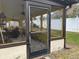 Enclosed sunroom with ironwork security door and views of the backyard and white fence at 3210 Little Oak Way, Orlando, FL 32812