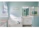 Bright bathroom featuring a soaking tub, large mirror, and a glass walk-in shower at 3320 Ashmount Dr, Orlando, FL 32828