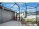 Outdoor patio featuring screened enclosure, dining table, and a view of the backyard at 3320 Ashmount Dr, Orlando, FL 32828