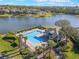 Aerial view of a community pool and lake, surrounded by palm trees and lush landscaping, providing a resort-like experience at 3320 Ashmount Dr, Orlando, FL 32828