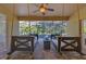 Covered back porch featuring comfortable hanging swing benches overlooking the screened-in pool area at 3443 Players Point Loop, Apopka, FL 32712