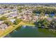 Aerial view of homes with landscaped lawns, fenced yards, and a scenic pond at 3722 Madbury Cir, Lakeland, FL 33810