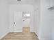 Bright hallway with wood-look floors and a view into a laundry room with white cabinets at 3722 Madbury Cir, Lakeland, FL 33810