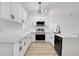 Bright kitchen featuring white cabinets, stainless steel appliances, and modern pendant lighting at 3722 Madbury Cir, Lakeland, FL 33810