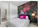 Bedroom featuring bright tropical wallpaper, bed with pillows, side table, and closet at 4068 Stone Creek Loop, Lake Wales, FL 33859