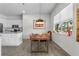 Dining room with modern light fixture, industrial dining table and large bright window at 4068 Stone Creek Loop, Lake Wales, FL 33859