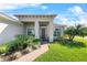 Inviting front entrance with brick walkway, lush landscaping, and a modern-style covered entryway at 4068 Stone Creek Loop, Lake Wales, FL 33859