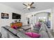 Open-concept living room featuring a grey sectional sofa, neutral decor, and ample natural light at 4068 Stone Creek Loop, Lake Wales, FL 33859