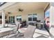 Covered patio featuring outdoor kitchen area, ceiling fans, dining set, and lounge chairs at 4068 Stone Creek Loop, Lake Wales, FL 33859