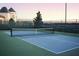 A tennis court shows its net, fencing, and a glimpse of the building in the background at 4068 Stone Creek Loop, Lake Wales, FL 33859