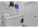 White laundry room with washer, dryer, shelf, and door at 408 Orista Dr, Davenport, FL 33897