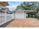 A detached garage featuring a white door and a convenient covered carport area, adding parking at 415 W Rich Ave, Deland, FL 32720