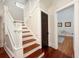 Hallway features hardwood stairs and dark wood door leading to living area at 415 W Rich Ave, Deland, FL 32720