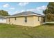 Tan home featuring white-trimmed windows, neutral roof and screened-in porch is set on a green lawn at 4431 Clubhouse Rd, Lakeland, FL 33812