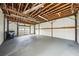 Spacious garage with exposed wooden beams, white walls, and painted gray flooring at 4431 Clubhouse Rd, Lakeland, FL 33812