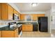 Well-lit kitchen with wooden cabinets, black appliances, and tile floors at 4431 Clubhouse Rd, Lakeland, FL 33812