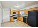 Bright kitchen with wood cabinets, black appliances, and easy access to the exterior door at 4431 Clubhouse Rd, Lakeland, FL 33812