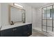 Modern bathroom featuring a double vanity, large mirror, and updated glass-door shower with marble tiling at 4940 Spring Run Ave, Orlando, FL 32819