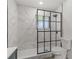 Modern bathroom features a shower with a stylish black-framed glass door and marble tiling at 4940 Spring Run Ave, Orlando, FL 32819