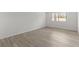 Bright, empty bedroom featuring wood-look flooring, white walls, and a window at 4940 Spring Run Ave, Orlando, FL 32819