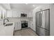 Bright kitchen featuring white cabinetry, stainless steel appliances, and light wood-look flooring at 4940 Spring Run Ave, Orlando, FL 32819