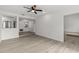 Open-concept living room with wood floors, a ceiling fan, and seamless flow to the kitchen at 4940 Spring Run Ave, Orlando, FL 32819