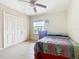 Comfortable bedroom with tile flooring, a ceiling fan, and a spacious closet, enhancing the living space at 5255 Images Cir # 305, Kissimmee, FL 34746