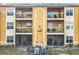 Exterior view of a three-story condo with balconies and screened in patios and AC units below at 5255 Images Cir # 305, Kissimmee, FL 34746