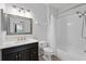 Well-lit bathroom featuring a shower-tub combo with a shower curtain, vanity, and a decorative mirror at 584 Brantley Terrace Way # 209, Altamonte Springs, FL 32714