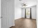 Bright bedroom with wood floors, ceiling fan, window with curtains, and a closet door at 584 Brantley Terrace Way # 209, Altamonte Springs, FL 32714