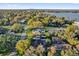 Expansive aerial view of a neighborhood with mature trees, lush lawns, and glimpses of a lake in the background at 7545 Lake Dr, Belle Isle, FL 32809