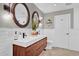 Modern bathroom with a double sink vanity, white subway tile, and round mirrors at 7545 Lake Dr, Belle Isle, FL 32809