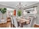 Dining room with wood floors, rustic chandelier, and view to the living room at 7545 Lake Dr, Belle Isle, FL 32809