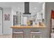 Modern kitchen with a butcher block countertop, a sleek hood vent and stainless steel appliances at 7545 Lake Dr, Belle Isle, FL 32809