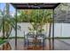 Stylish outdoor dining area with a modern pergola featuring a ceiling fan at 7545 Lake Dr, Belle Isle, FL 32809