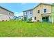 Wide backyard view of townhomes, colorful exteriors, and Adirondack chairs on patios at 8146 Coconut Pl, Kissimmee, FL 34747