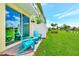 Backyard patio featuring blue Adirondack chairs and table with sliding glass door to home at 8146 Coconut Pl, Kissimmee, FL 34747