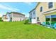 Lawn and backyard view of townhomes, colorful exteriors, and Adirondack chairs on patios at 8146 Coconut Pl, Kissimmee, FL 34747