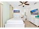 Bright bedroom featuring a ceiling fan, TV, white furniture and decor, and an ensuite bathroom at 8146 Coconut Pl, Kissimmee, FL 34747