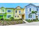 Charming colorful townhome showcasing a landscaped front yard with lush greenery and palm trees at 8146 Coconut Pl, Kissimmee, FL 34747