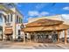 Outdoor kitchen bar under thatched roof with seating, ambient lighting, and tropical accents at 8146 Coconut Pl, Kissimmee, FL 34747