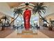 An impressive lobby boasting towering palm trees, and a whimsical giant red flip-flop sculpture in a glass case at 8146 Coconut Pl, Kissimmee, FL 34747