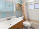 Bathroom featuring a sink, toilet, bathtub with shower, and seashell themed decor at 8430 Pamlico St, Orlando, FL 32817