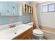 Bathroom featuring a sink, toilet, bathtub with shower, and seashell themed decor at 8430 Pamlico St, Orlando, FL 32817