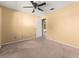 Bedroom featuring neutral carpet, walls, and ceiling fan with an open door to a bathroom at 8430 Pamlico St, Orlando, FL 32817