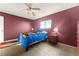 Bedroom with a ceiling fan, red accent wall and blue bedding at 8430 Pamlico St, Orlando, FL 32817