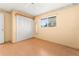 Bedroom with wood floor, window, closet, and light-colored wall with floral accents at 8430 Pamlico St, Orlando, FL 32817