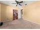 Bedroom featuring neutral carpet, walls, ceiling fan and a bookcase full of books at 8430 Pamlico St, Orlando, FL 32817