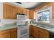 Functional kitchen with wooden cabinets, an oven, and a sink, all set in a modern design at 8430 Pamlico St, Orlando, FL 32817